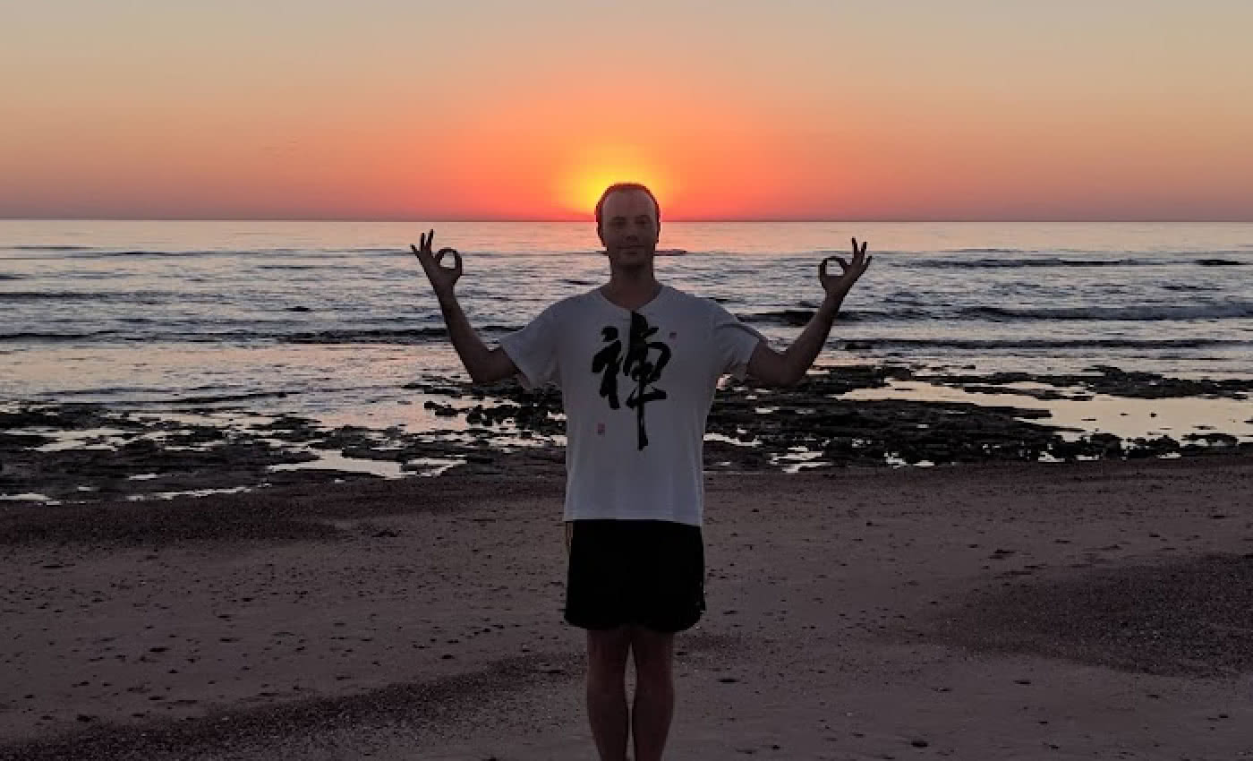 Ramiro doing a funny pose in front of a beach sunset